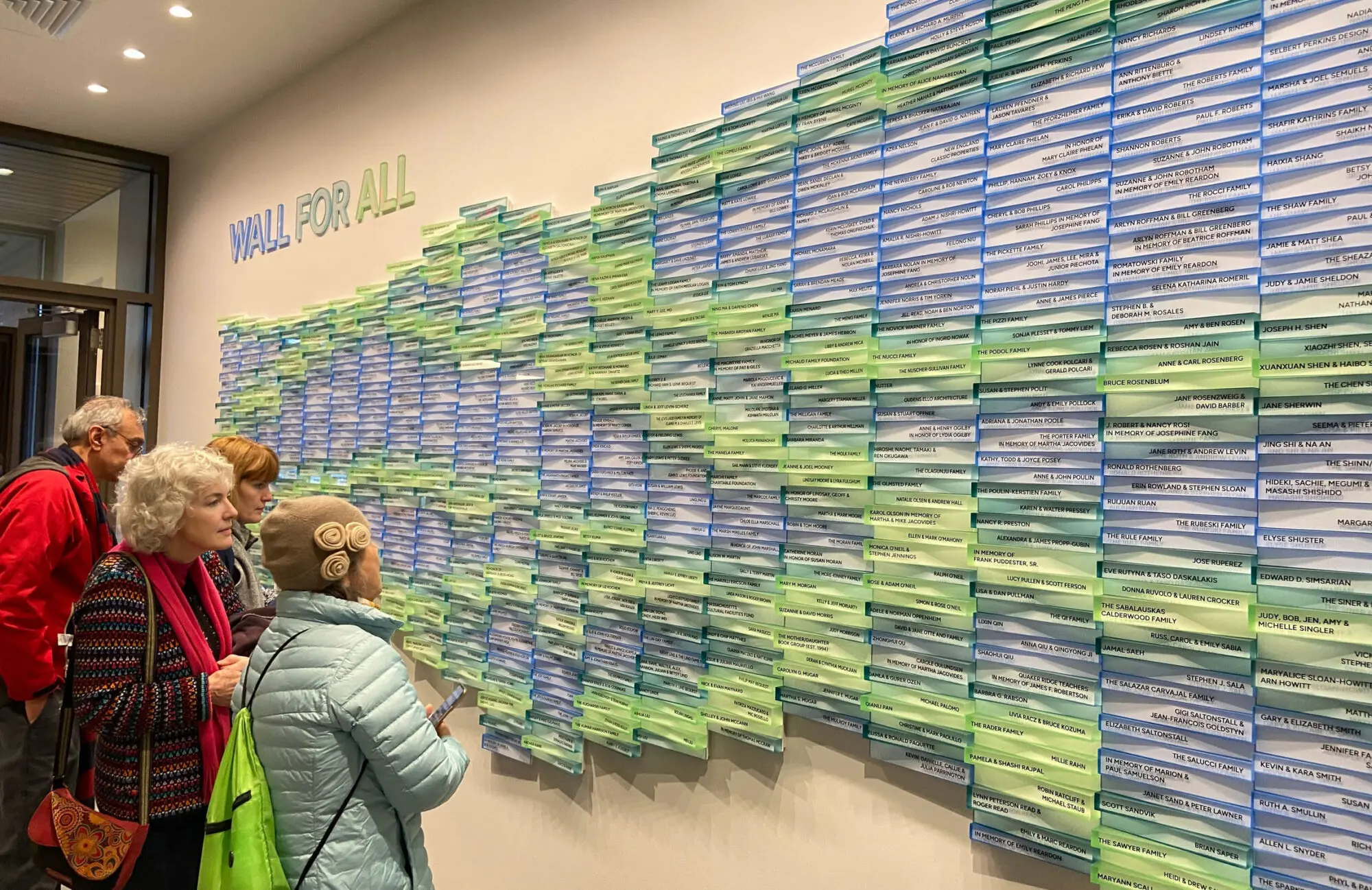 Visitors viewing the colorful donor wall at the Belmont Public Library